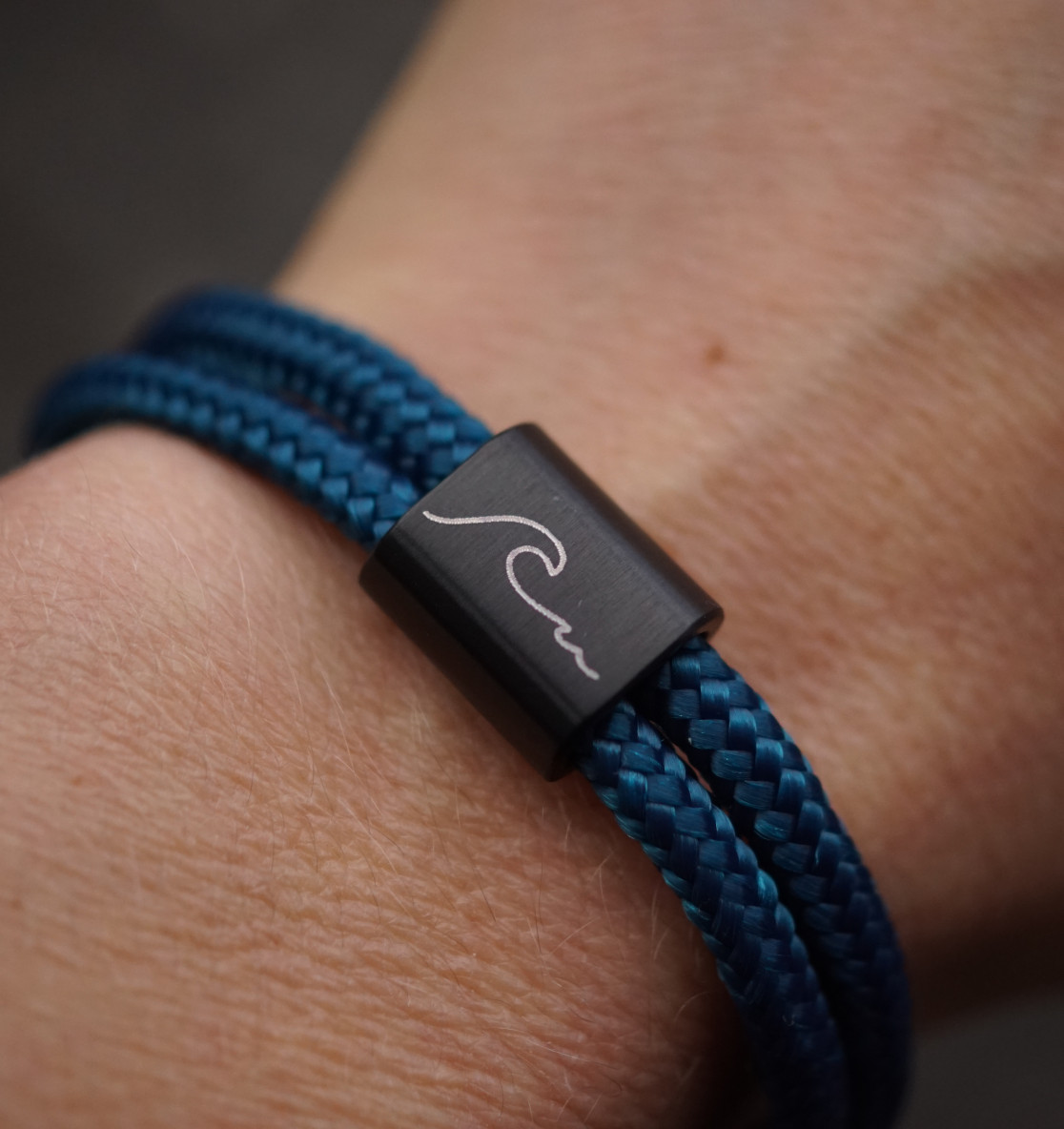 Wave Wellen Armband aus graviertem Edelstahl und blauen Segeltau. Ein besonderes Meeresschutz Armband, auch perfekt als Suferarmband oder als maritimes Geschenk.