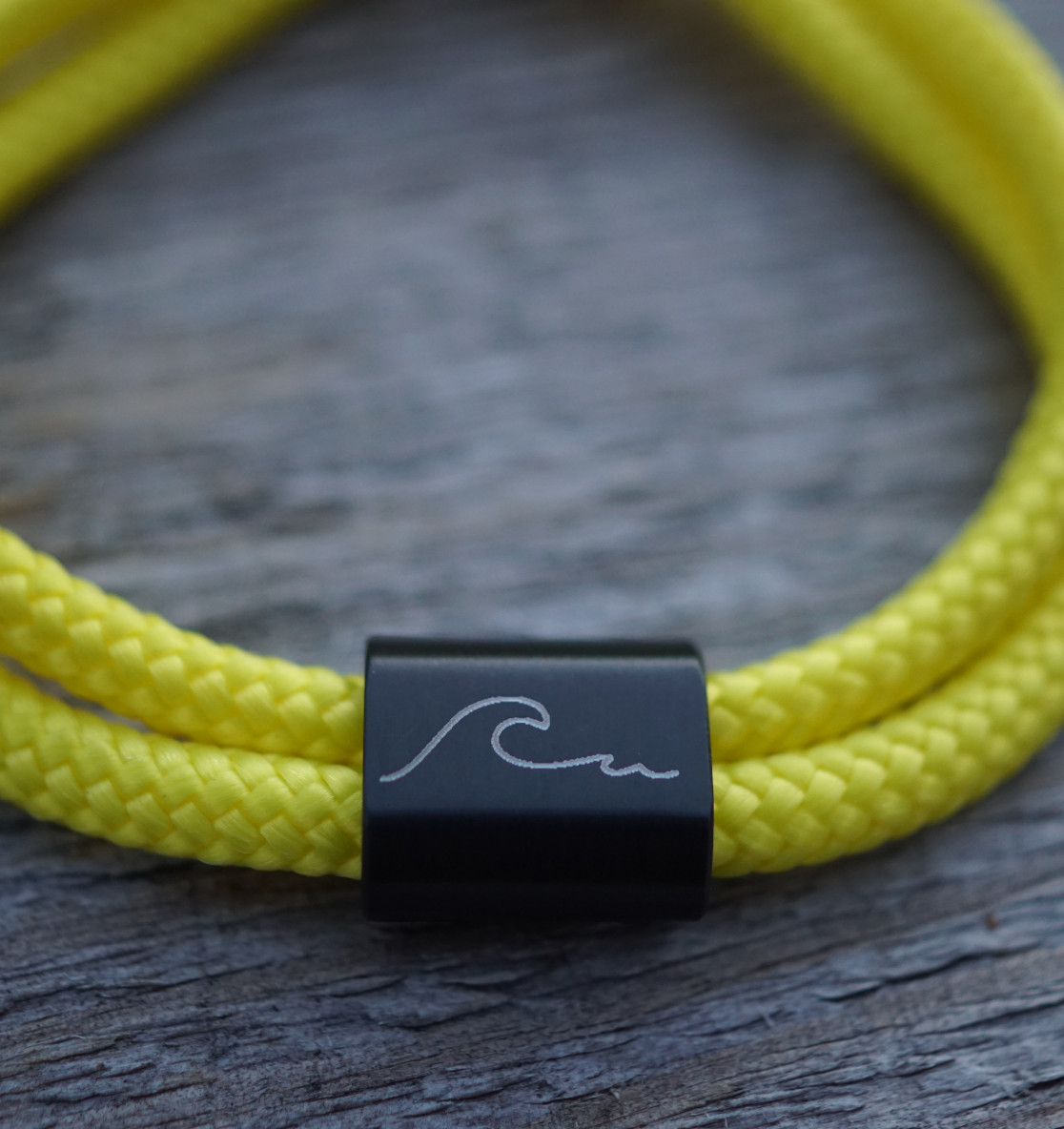 Wave Wellen Armband aus graviertem Edelstahl und gelben Segeltau. Ein besonderes Meeresschutz Armband, auch perfekt als Suferarmband oder als maritimes Geschenk.